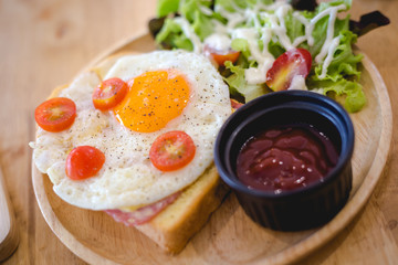 Sandwich ham cheese with fried egg on top serve with wooden plate