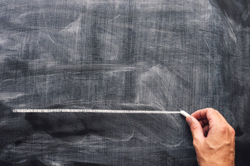 Hand underlining with chalk on school blackboard