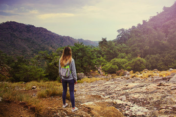 Fototapeta premium Young beautiful girl in the hoodie shirt and touristic backpack looking on amazing landscape from the mountain of Hemera, Turkey.