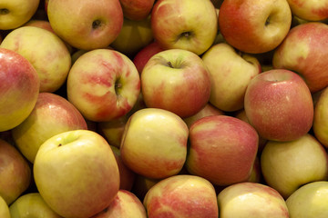 Pile of fresh orange and yellow apples top view close up.