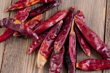 Collection of spicy chinese dried chili peppers sitting on wooden table top