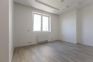 Empty white room with wooden parquet floor after renovation
