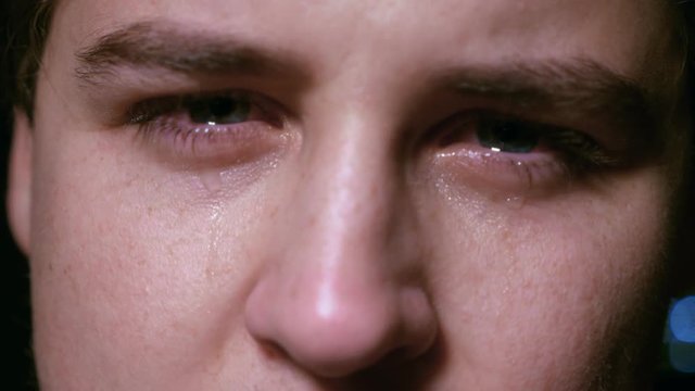 depressed young man crying - macro