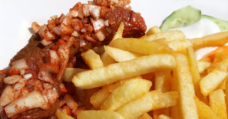 Berliner Curry-Wurst mit Pommes und scharfen Zwiebeln