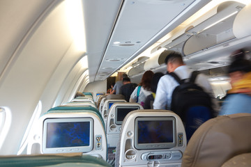 Fototapeta premium Pasażerowie wysiadają z klasy ekonomicznej kabiny samolotu