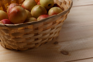 nectarines in a wicker basket on a wooden table, top view