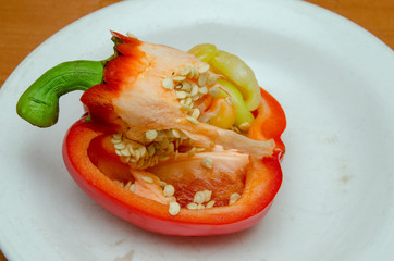 red pepper lies on a plate, pepper with seeds