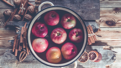 Ripe red apples in a saucepan for mulled wine on a wooden table. Top view