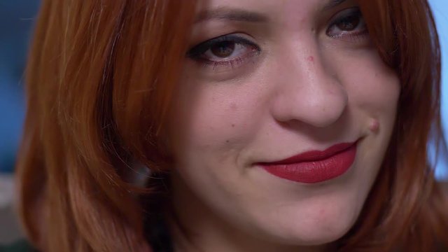Beautiful young red hair woman smiling at camera - macro