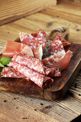 Food tray with delicious salami, raw ham and italian crudo or jamon. Meat platter with selection