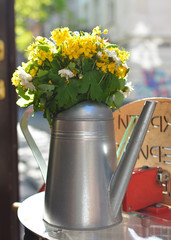 A table with flowers of a street cafe, a soft focus. Free space.