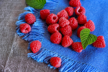 Ripe berry raspberries on the table. Blue background.