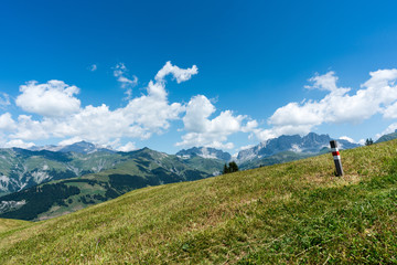 idyllic mountain landscape with a hiking trail and trail marker in the foreground and a great view