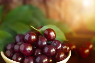 Ripe cherry by close-up, on a sunset background, outdoors