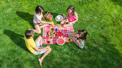 Happy family having picnic in park, parents with kids sitting on grass and eating healthy meals outdoors, aerial view from above
 - obrazy, fototapety, plakaty