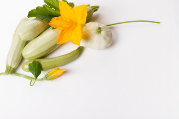 Fresh green zucchini with flower and leaves on white background. The concept of healthy eating, baby food, veganism, vegetarianism, raw food. Overhead top view, flat lay. Copy space.