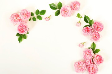 Flowers background. Beautiful pale pink roses frame on white background. Top view. Copy space. Flat...