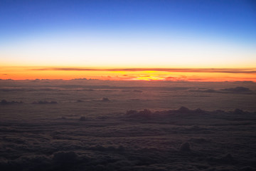 Fototapeta na wymiar Aerial scenery of sunset over the clouds