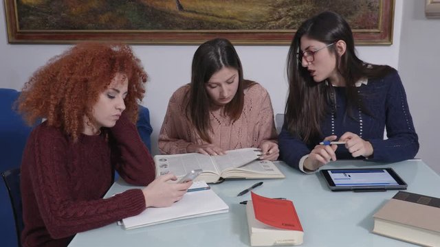 Study group. student is distracting by the smartphone, her friend scolding her