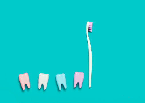 Toothbrush and many teeth on blue background. Minimal
