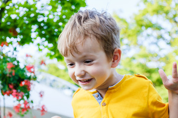 Happy caucasian boy smiling enjoying life. Portrait of young boy in nature, park or outdoors. Concept of happy family