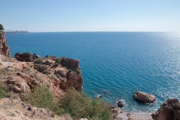 Sea bay in Antalya. Beautiful secluded bay for rest. Rest in Turkey in natural conditions by the sea. Fisherman on a rock in the sea.
