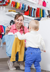 Adult woman choosing clothes with little son