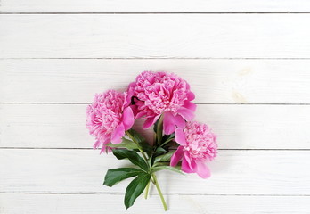 Flowers background. Bouquet of beautiful pink peonies on white wooden background. Copy space. Top view