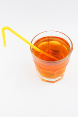 Apple juice in a transparent glass, freshly squeezed fruit juice on a white background, yellow cocktail tube with a healthy drink, healthy lifestyle, vegetarian drink, isolated