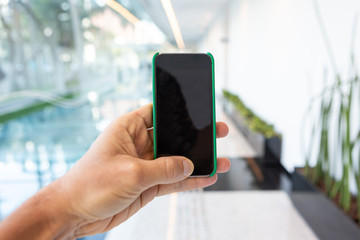 Close up of mobile phone with corporate environment blurred in the background.