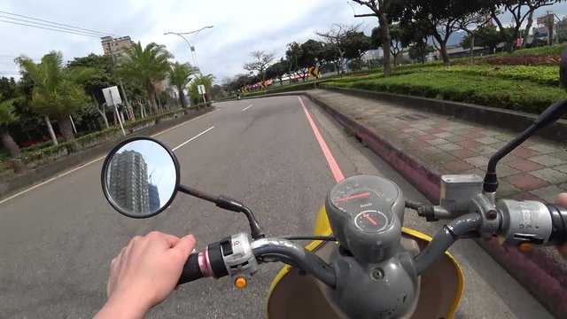 Point of view of a person riding a electric scooter down the streets of Tamsui in Taipei, Taiwan.