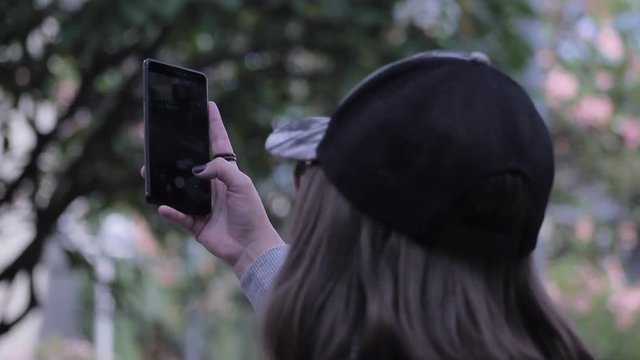 A young tourist woman taking pictures in the Botero Park of Medellin