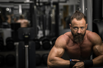 Obraz na płótnie Canvas Hombre fuerte con grandes músculos mirando de frente en el gimnasio.