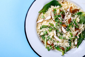 Salad Couscous almond greens Spinach micro greens with Olive Oil on a blue background Top View Copy space for Text  Flat Lay