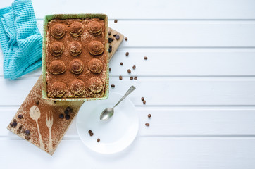 Tiramisu dessert on white wooden background. Top view with space to copy.