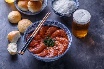 Close view of tiger prawn in chili sauce on dark background