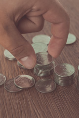 cropped image of man stacking ukrainian coins on tabletop, saving concept