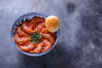 Bowl of shrimps in spicy tomato sauce, singaporean cuisine, copyspace