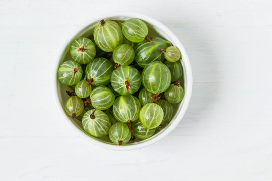 Ripe gooseberries in a bowl  on a white background.