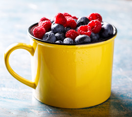 Berries Mix in the Yellow Cup.Golubica and Raspberry.Superfoods and healthy lifestyle or detox diet food concept.