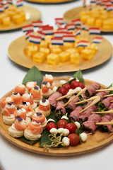 Dutch canapes on a white background. Pieces of traditional Dutch cheese with flag as a snack, top view