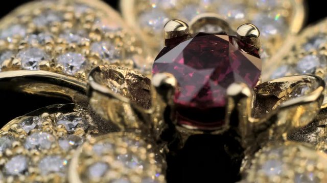 Amazing stunning ring with red ruby in gold jewelry with many sparkling and shining diamonds. Close up shot of beautiful, expensive and luxury jewel.