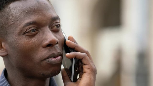 Relaxed american african young man talking by phone- close up