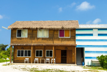  Wooden guest house under the roof of a dry palm leaf on a blue sky background, Kaafu Atoll, Kuda Huraa Island, Maldive
