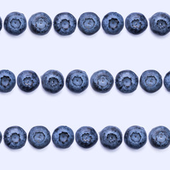 Seamless pattern with fresh blueberries on blue background.