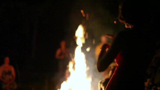 Women dancing around the fire at night