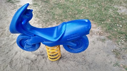 Electric blue plastic toy motorcycle to ride in a children playground 