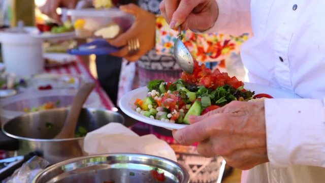 People Filling Up Their Plates At The Potluck