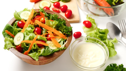 Mixed vegetables salad with cream on white background.
