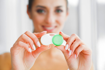 Vision And Medicine Concept. Young Girl Holds Eye Drops In Hands. Portrait of a Beautiful Woman with Contact Lenses. Healthy Look. High Resolution